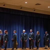 faculty line up on stage to receive their award